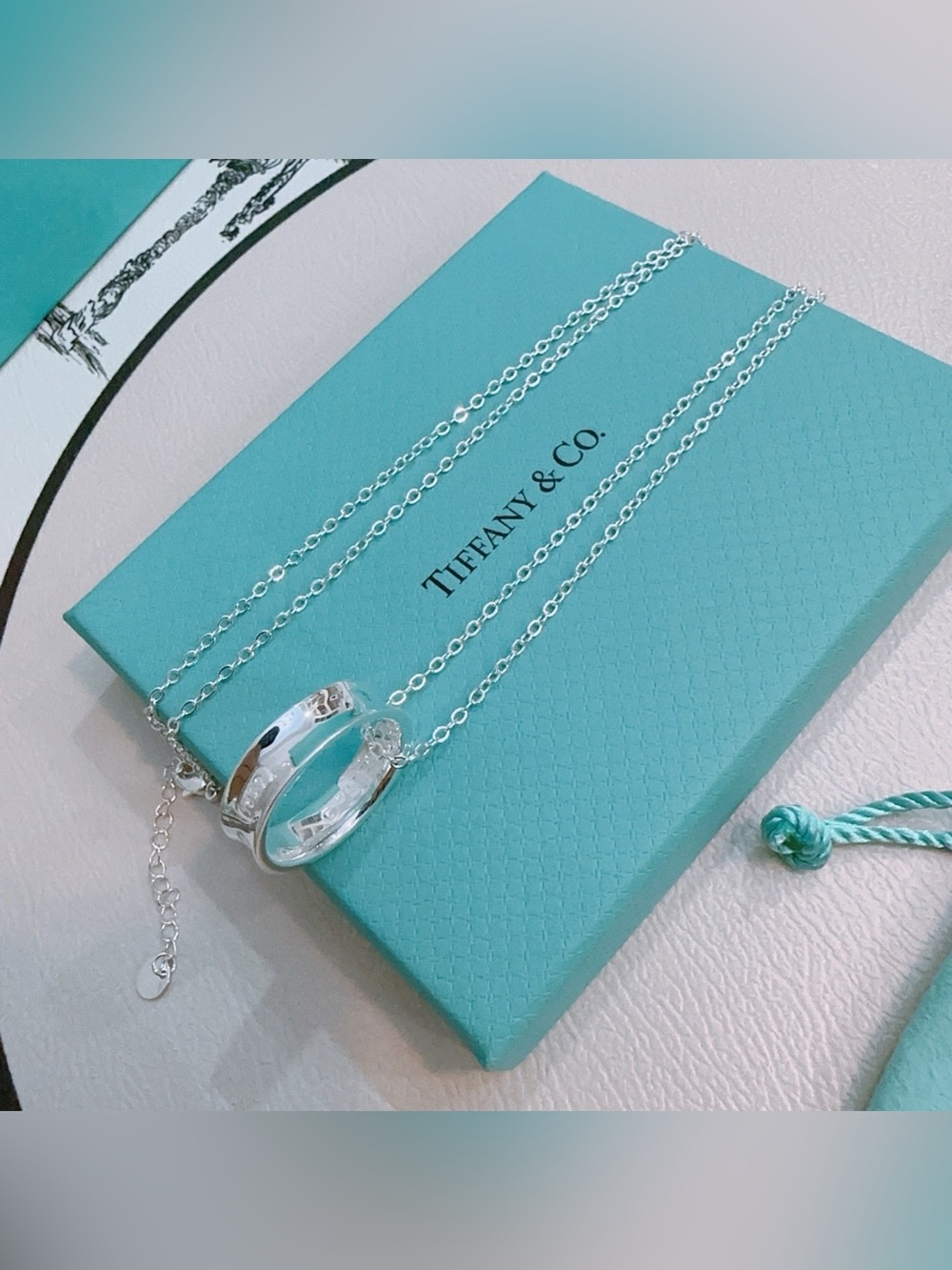 Tiffany & Co. Silver Interlocking Ring Necklace with Tiffany Blue Accent